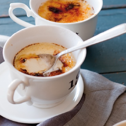 Two cardamom crème brûlées served in teacups.