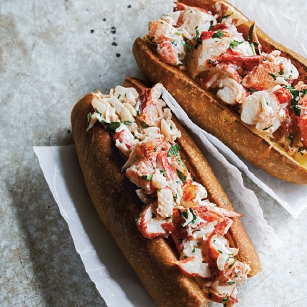 Classic lobster rolls loaded high with cooked lobster on buttered New England–style split-top buns.