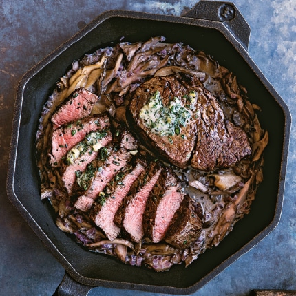 Beef tenderloin with red wine and mushroom pan sauce prepared in a cast iron skillet.