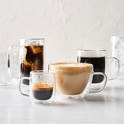 Multiple double wall glass coffee cups with different types of coffee in them.