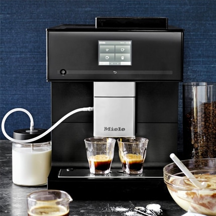 Miele CM7750 automatic espresso maker and coffee system with glasses of espresso.