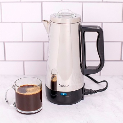Capresso coffee percolator on a counter top next to a glass mug of coffee.