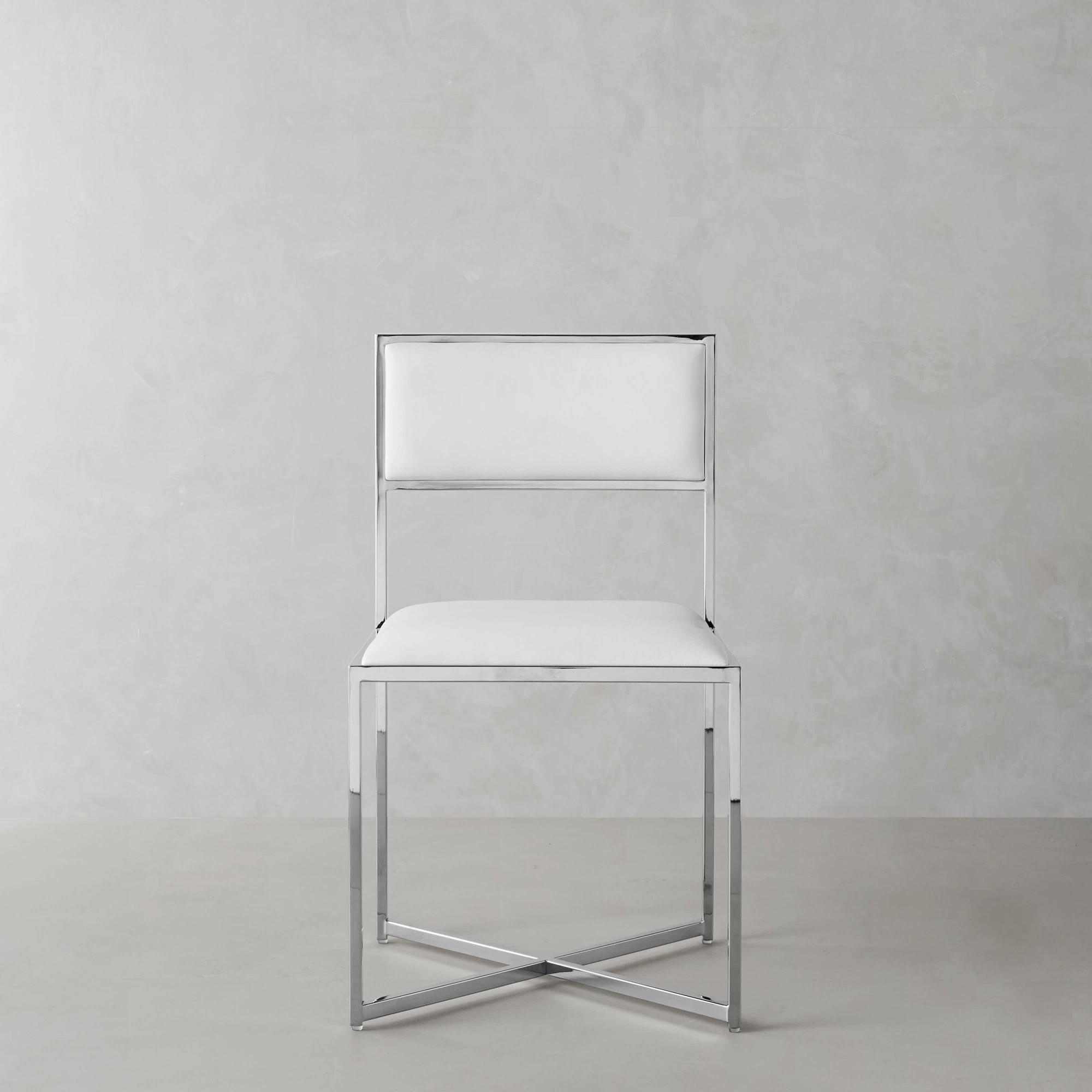 Close-up side view of a white upholstered chair seat with chrome frame, showing construction joints.