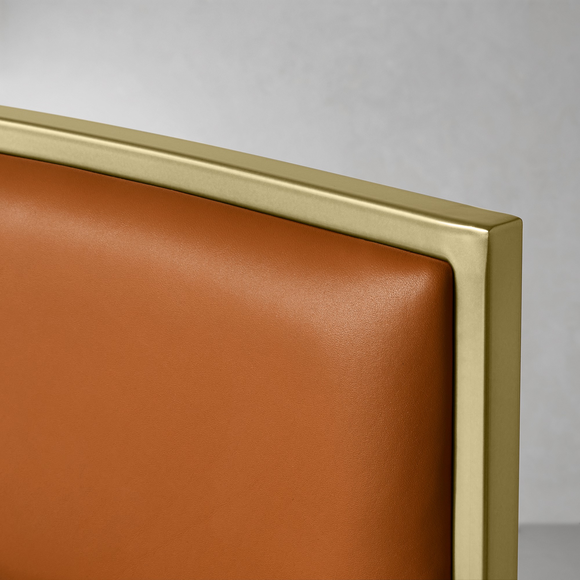 Macro shot of the top edge of the chair frame with beige leather upholstery.