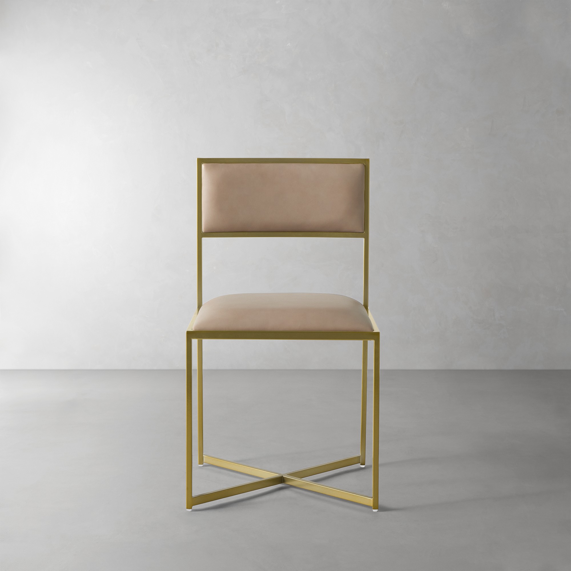 Chair with gold frame and tan upholstery shown from the side, single chair against a gray backdrop.
