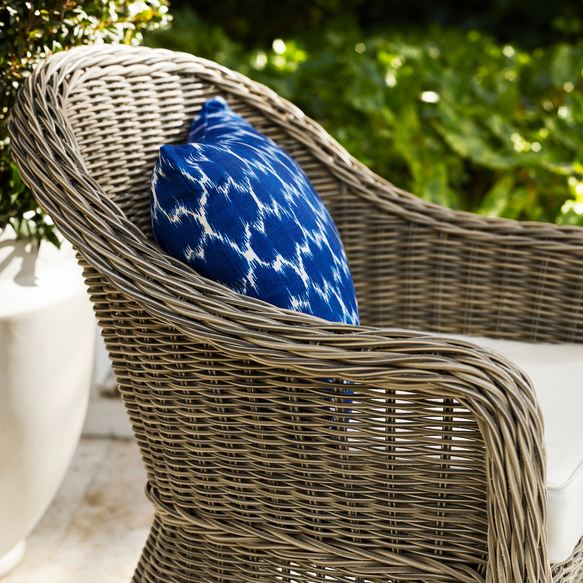 Close-up of a blue patterned pillow inside a wicker chair