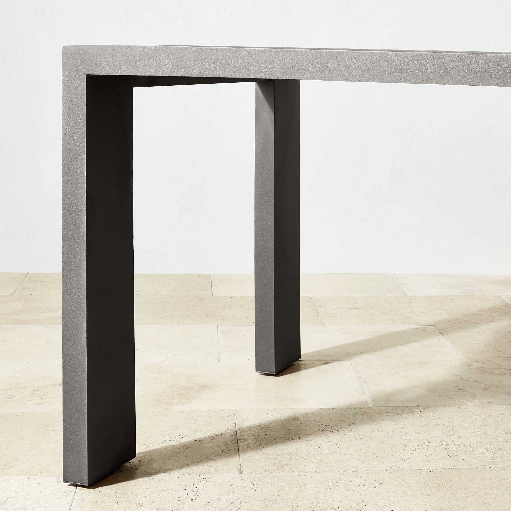 Close-up corner of a modern gray table leg with metal-like finish.