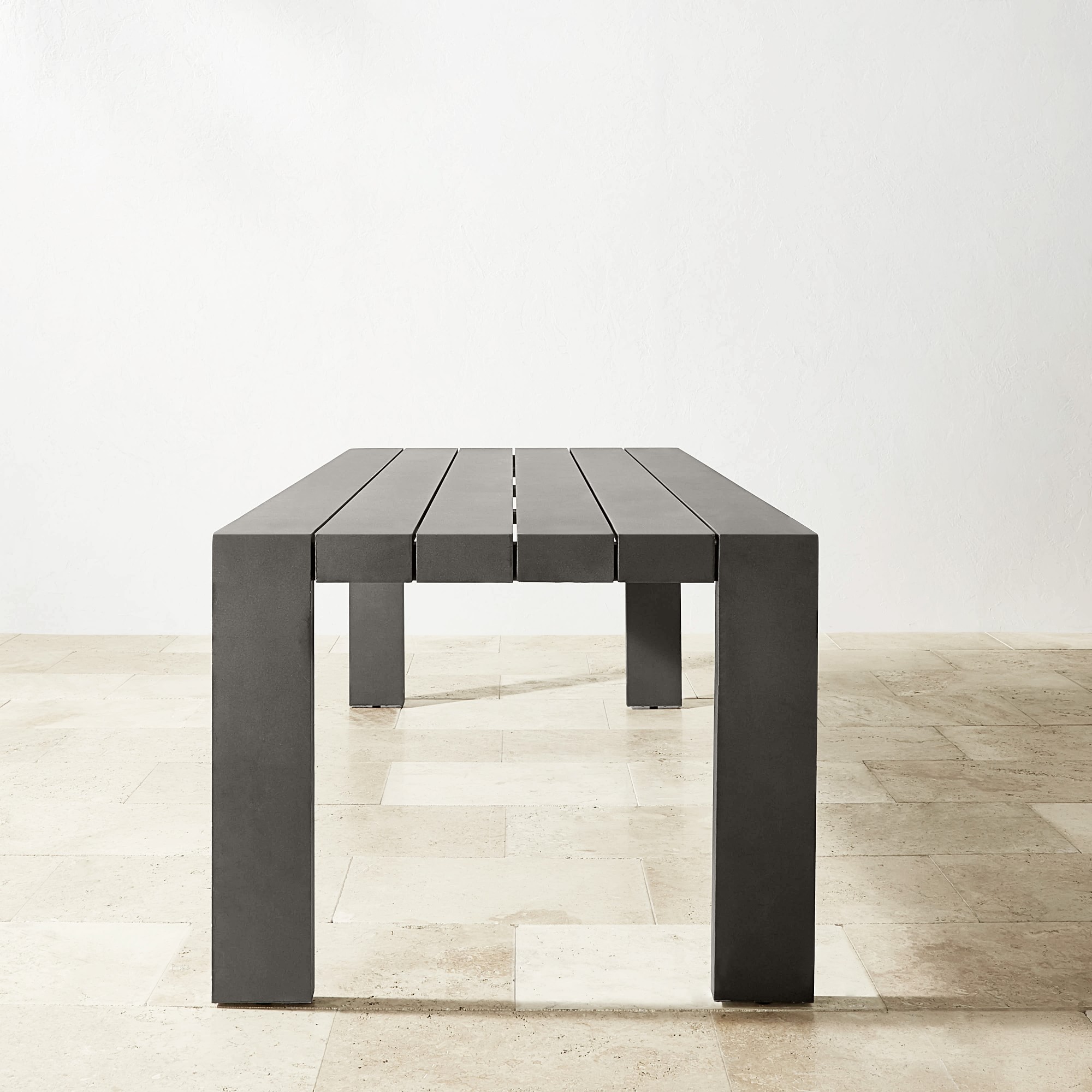 Close-up of table edge and leg showing squared profile and gray finish.