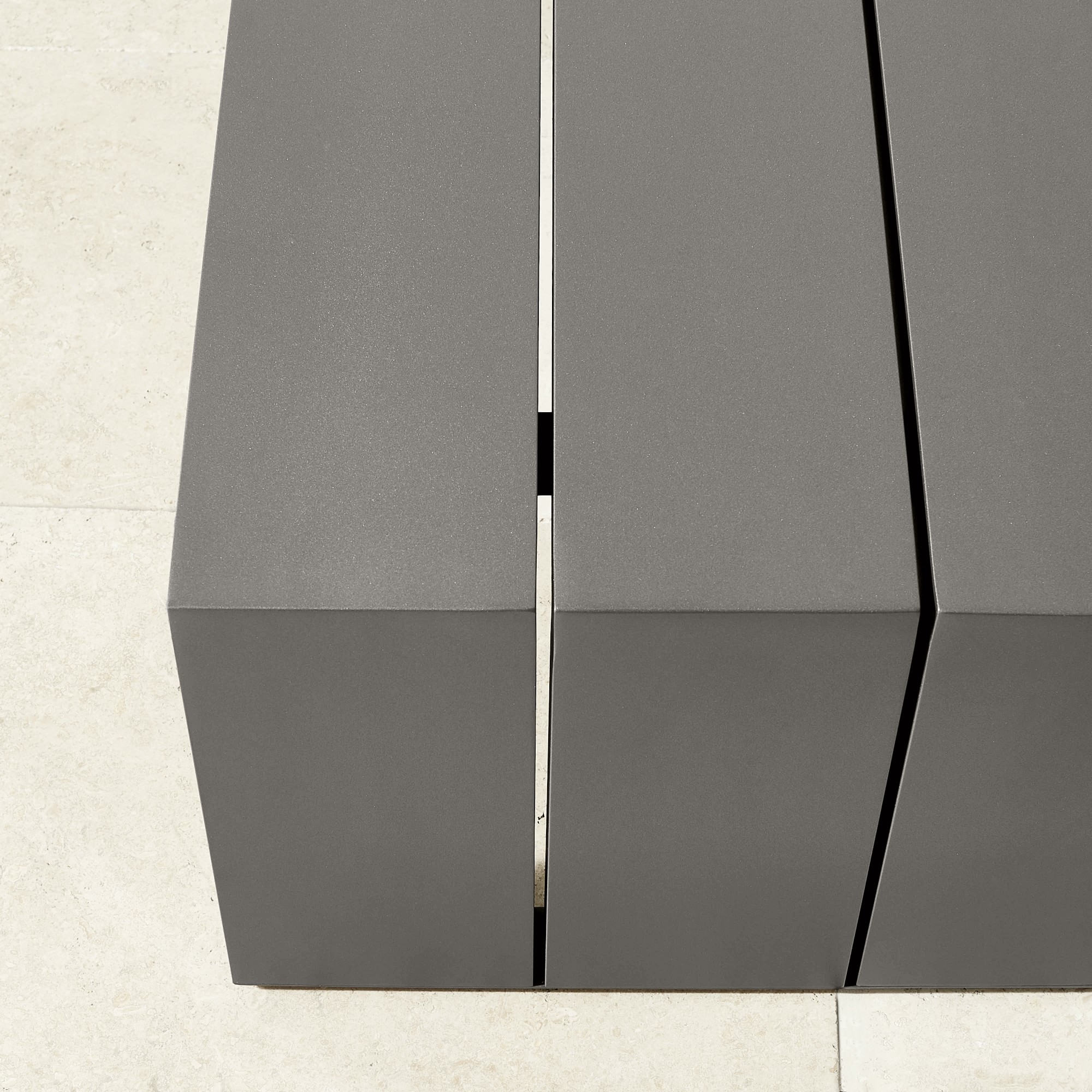 Close-up of the seam/gap between slats on the gray bench
