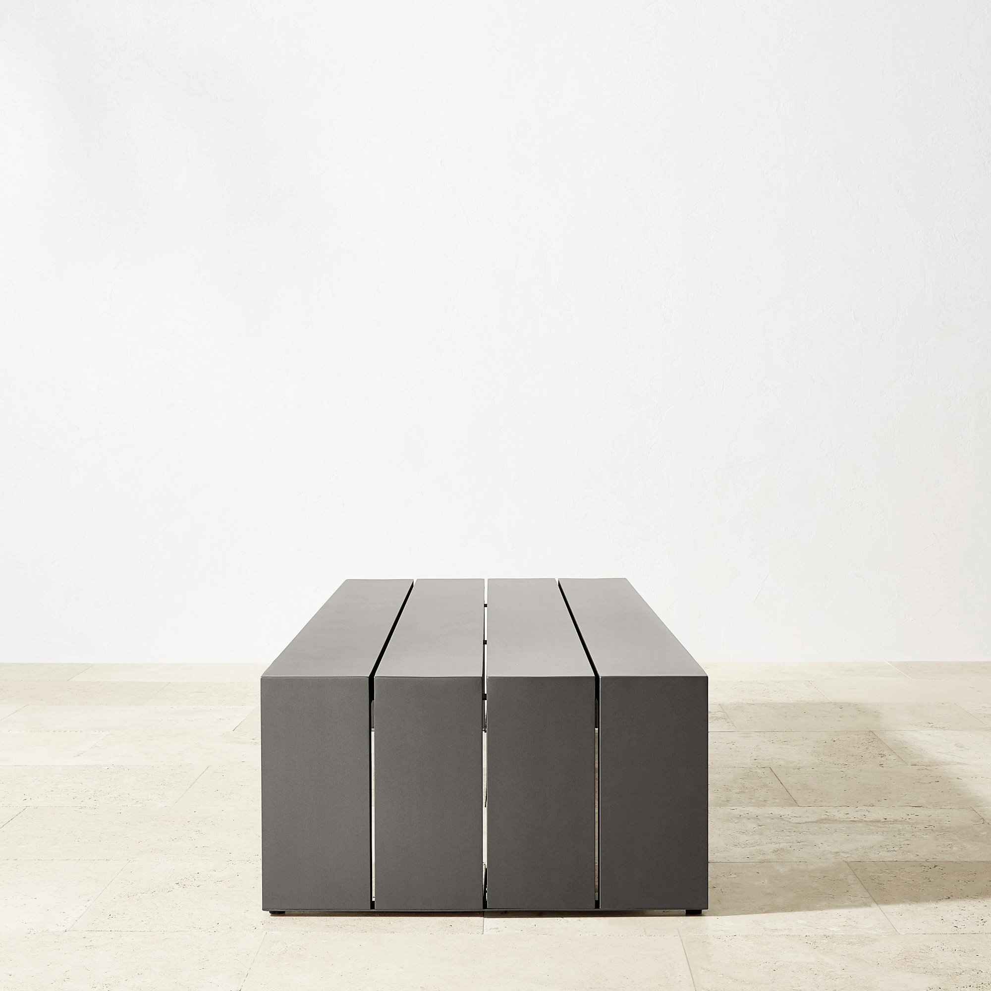 Close-up of a modern gray slatted bench from end perspective