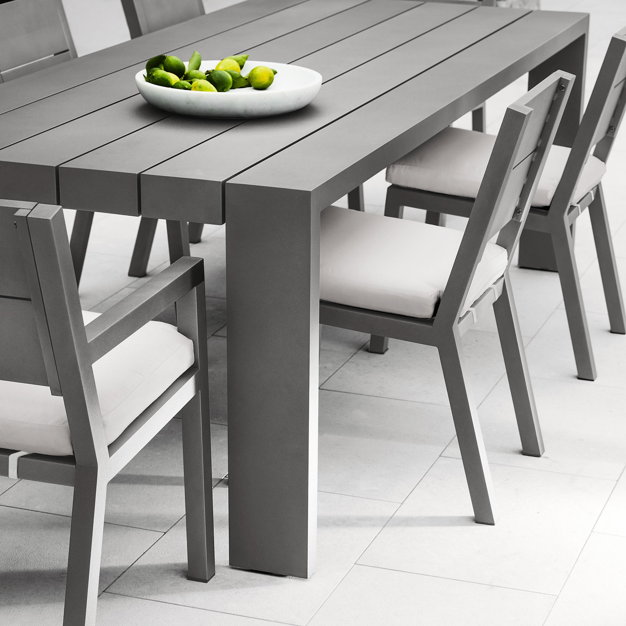 Close-up of a single chair with a plate of limes on the table.