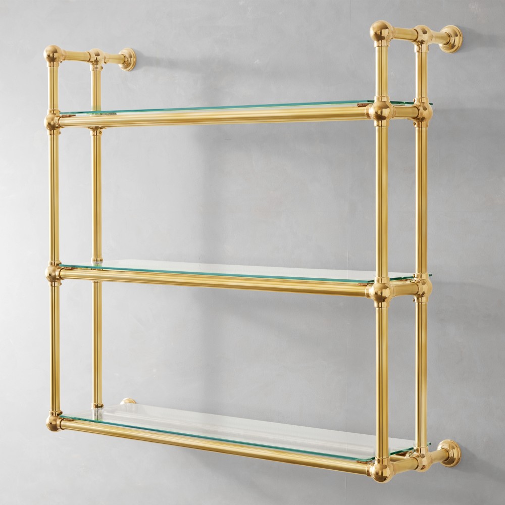 Three-tier brass and glass shelf mounted to wall