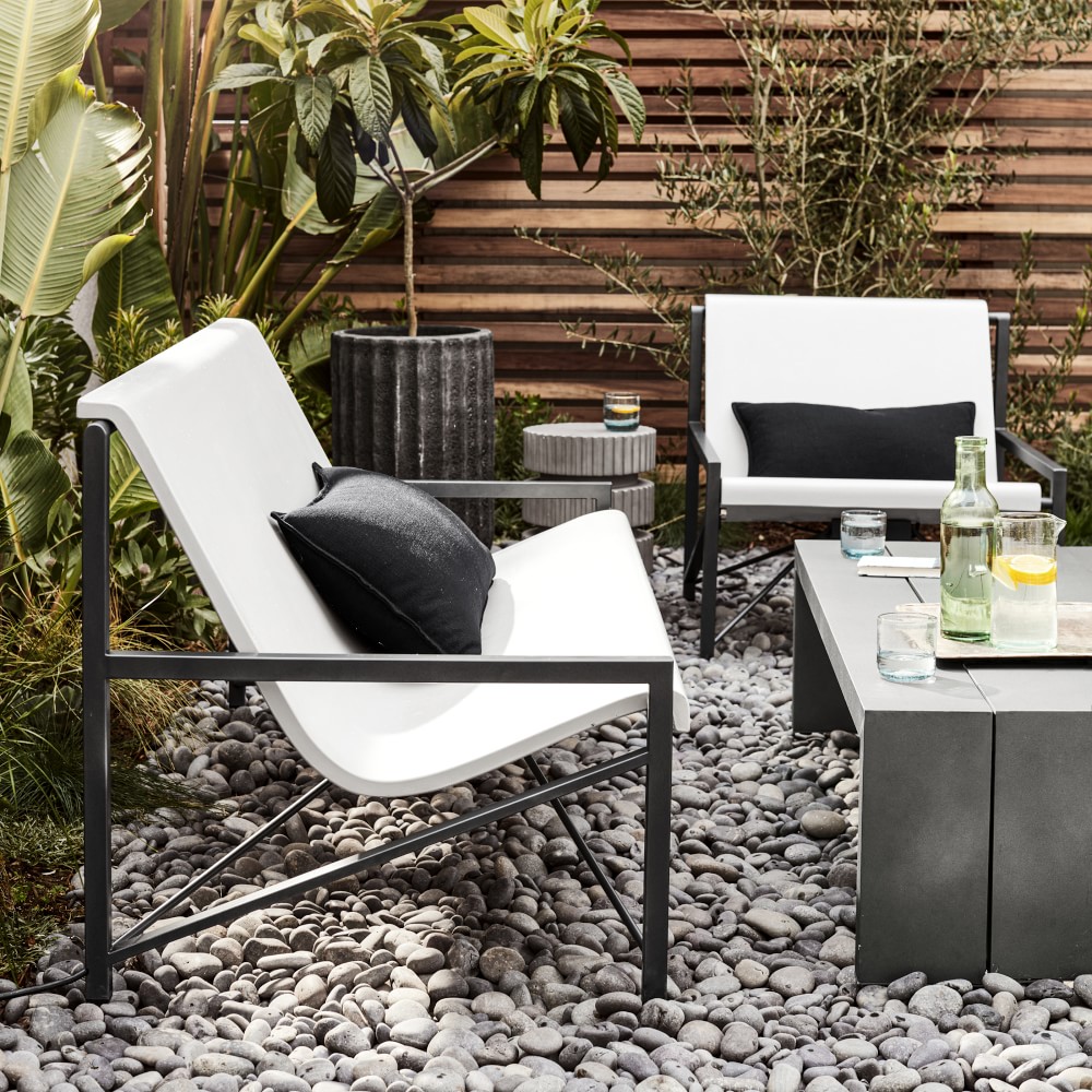 White outdoor chairs and sofa with black metal frames and cushions