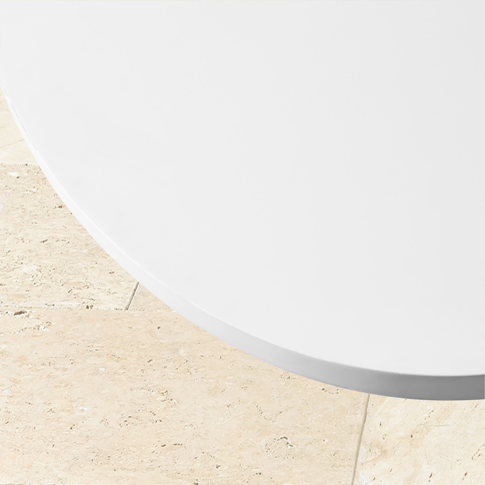 Edge of white oval tabletop against tiled floor