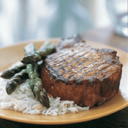 grilled hoisin pork chops with asparagus and rice on a plate.