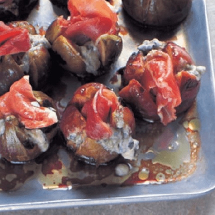 Grilled figs stuffed with prosciutto and gorgonzola in a baking dish.