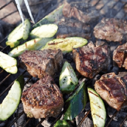 Rosemary garlic lamb chops cooking on a grill.