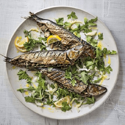 Tuna stuffed grilled sardines on a plate with lemon and rocket.