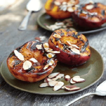 Maple glazed peaches sprinkled with almonds on a plate.