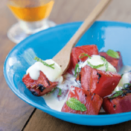 Watermelon with mint zabaglione being spooned out of a bowl.