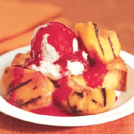 Grilled peach melba with ice cream on a plate.
