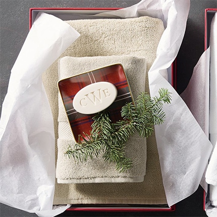 Gift box with personalized bar soap imprinted with the letters CWE and on a set of towels with a pine sprig.