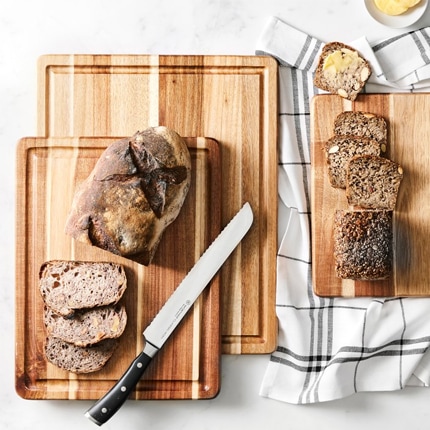 Williams-Sonoma cutting boards with bread, bread knife and butter. Williams-Sonoma cutting boards with bread, bread knife and butter.