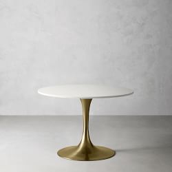 Round white tabletop with brass/gold pedestal base in a clean setting.