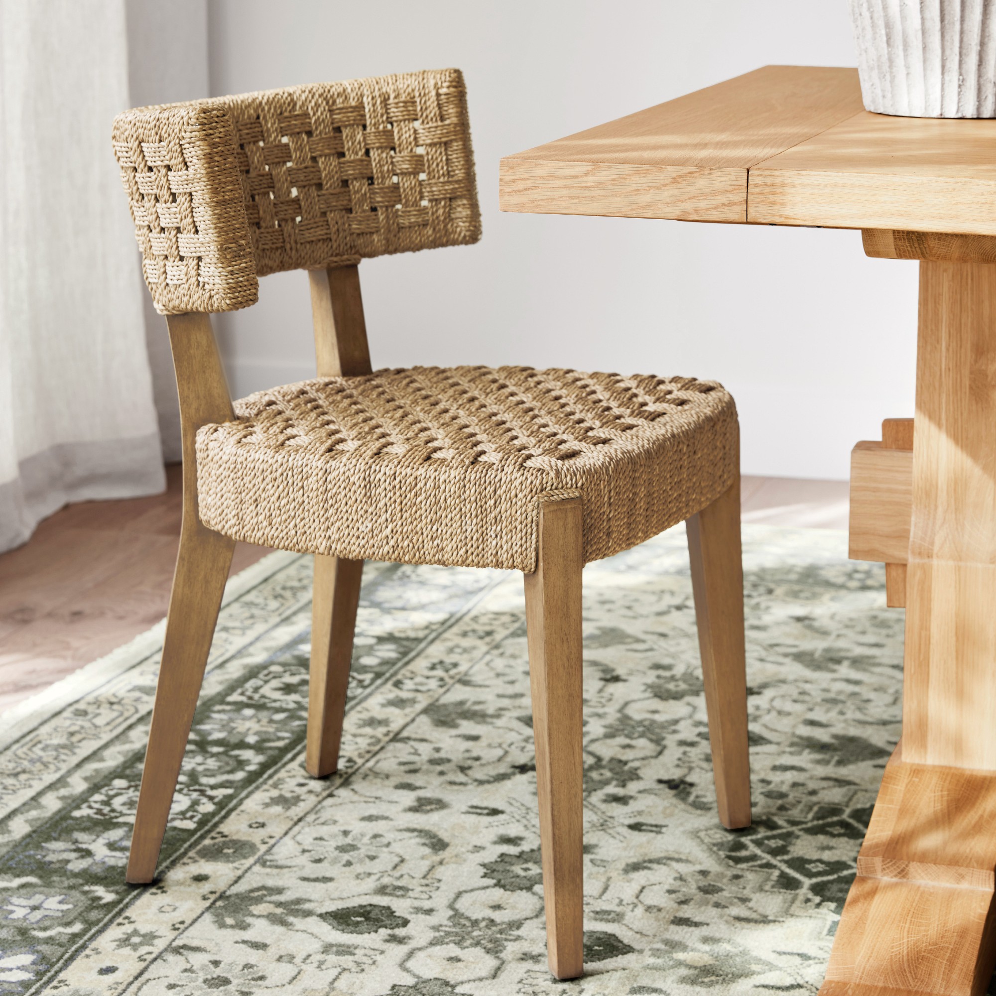 Close-up of a woven chair seat and back, showing the intricate weave and wooden legs.