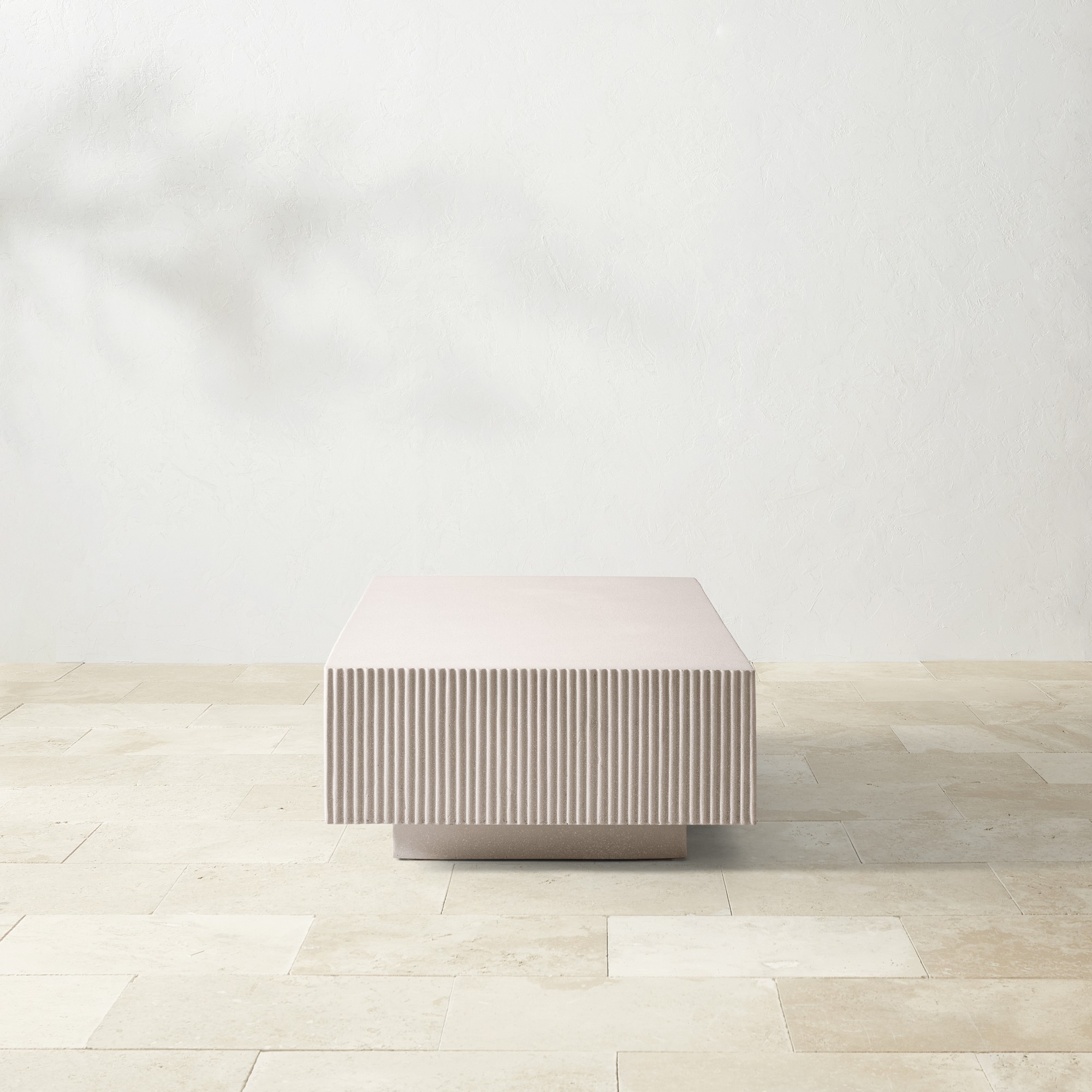 A beige, rectangular coffee table with a ribbed texture.