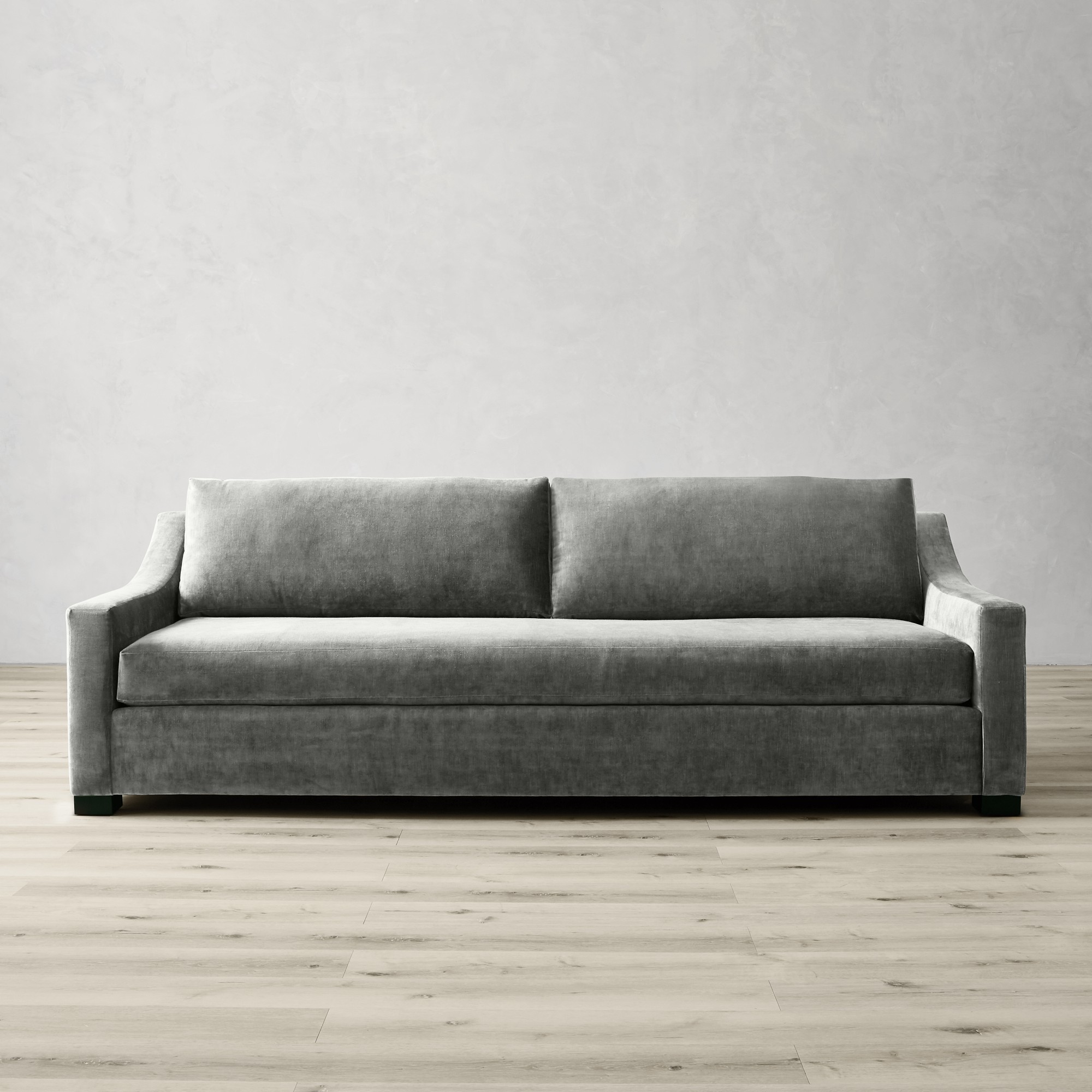 Close-up of the sofa corner with leg and base, revealing square black feet and fabric texture.