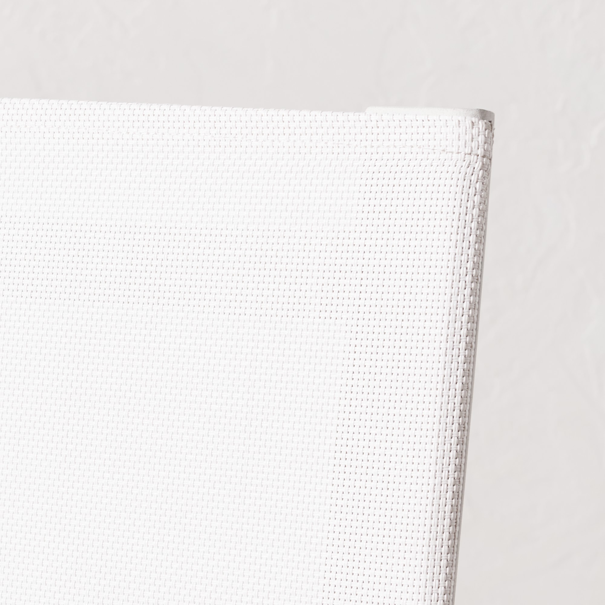 Close-up of white textured fabric on chair back with stitching