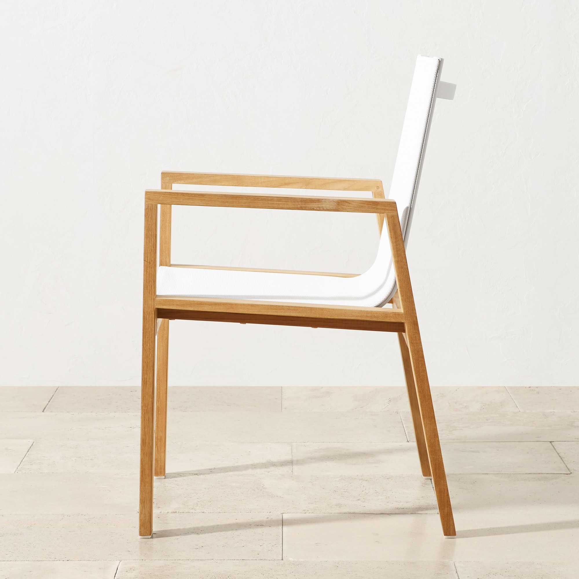 Stackable white fabric chair showing side profile and wooden legs