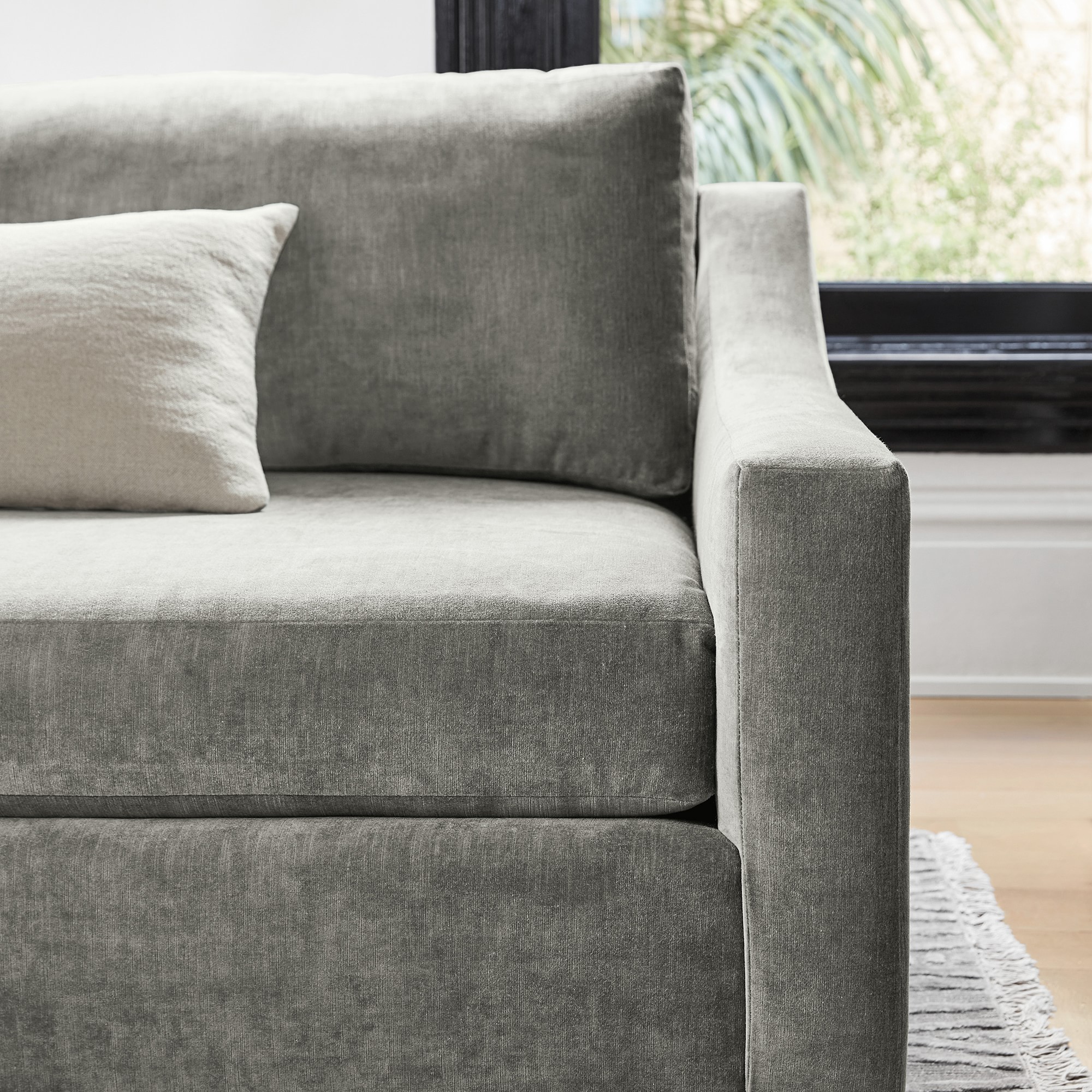 Side view of grey sectional arm showcasing curved arm profile and upholstery texture.