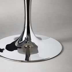 Close-up of a shiny chrome metal base of a stemmed table leg on a reflective surface.