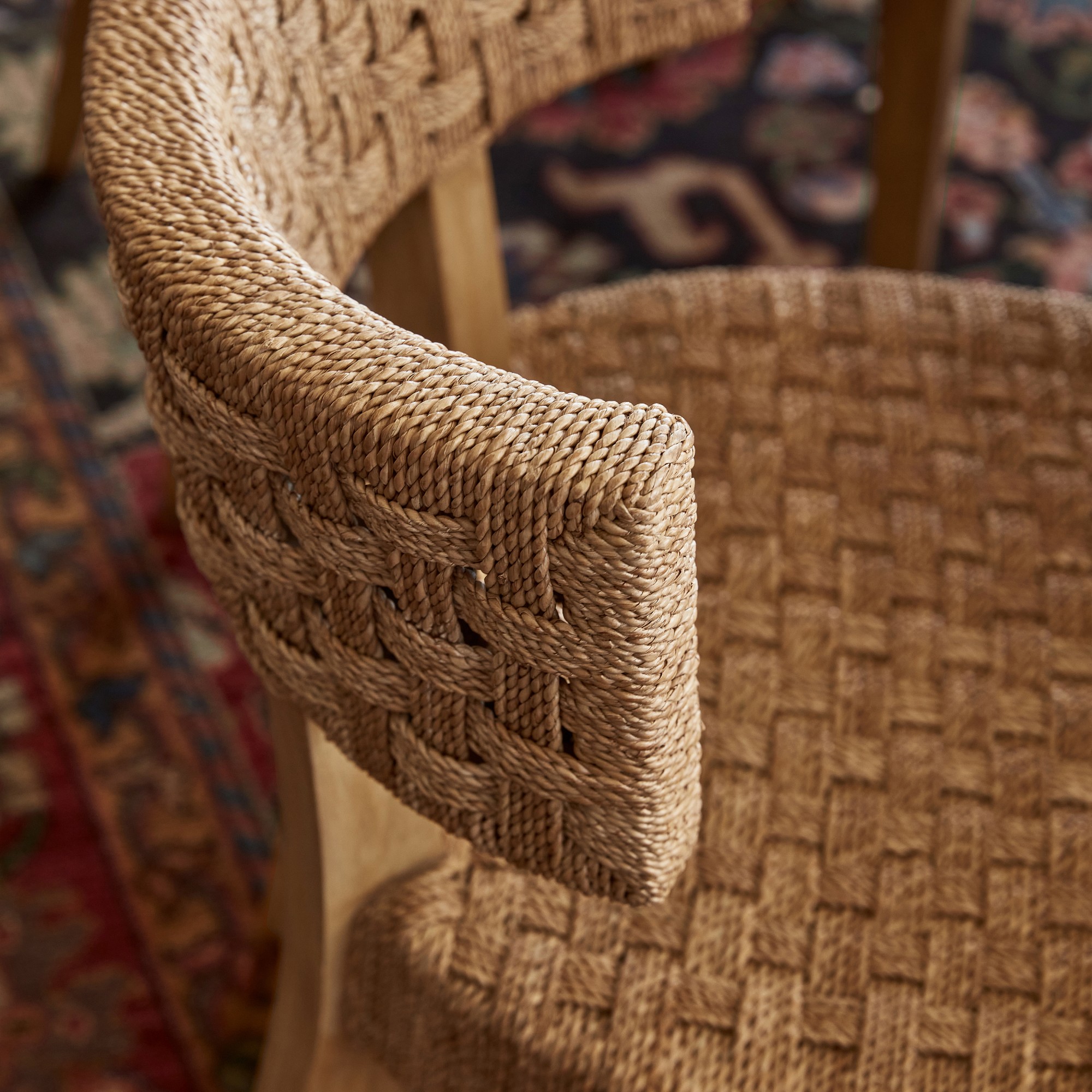 Close-up of the armrest and woven weave of a chair, highlighting the braided texture.
