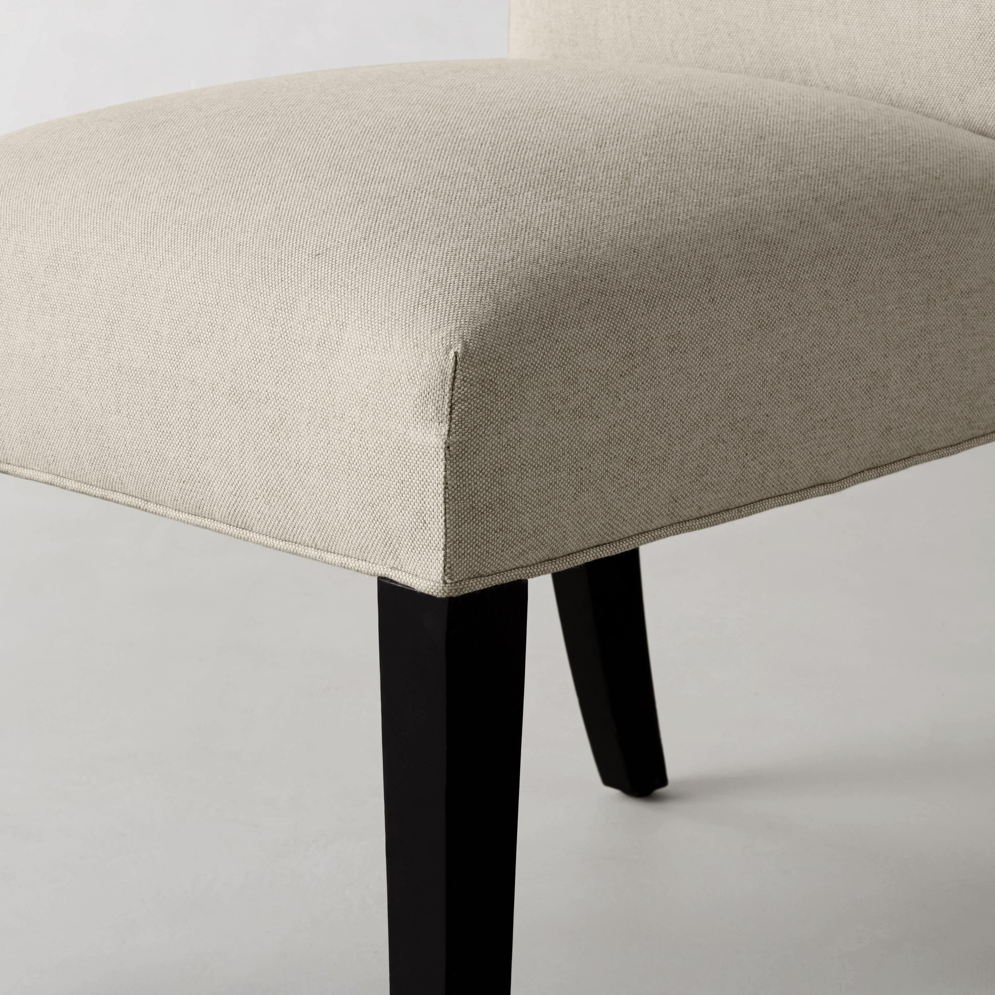 Close-up of chair seat corner with beige fabric