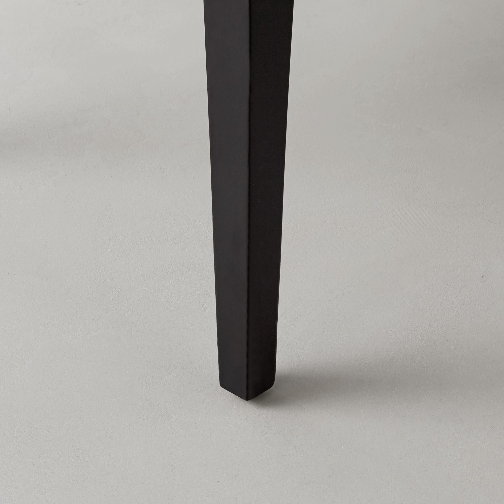 Black chair leg resting on light floor