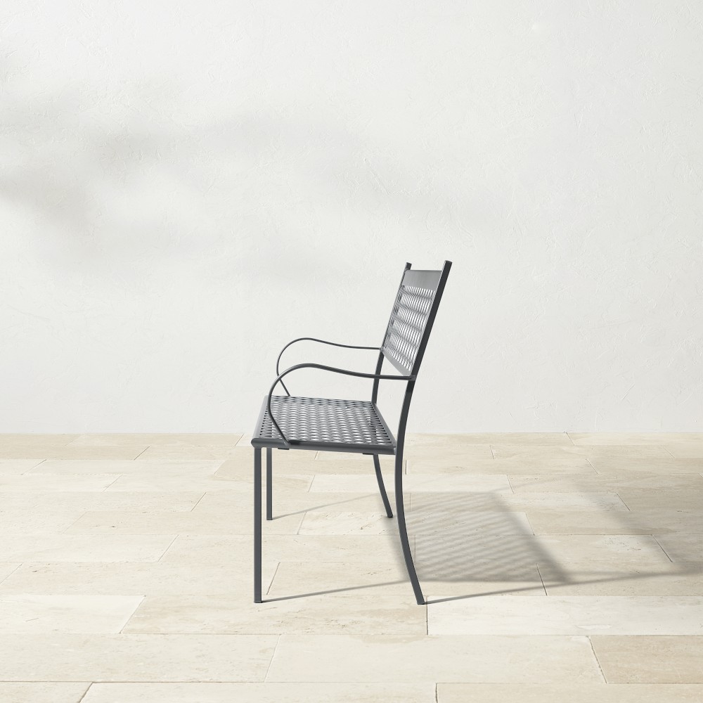 Side profile of metal bench with lattice back on white background