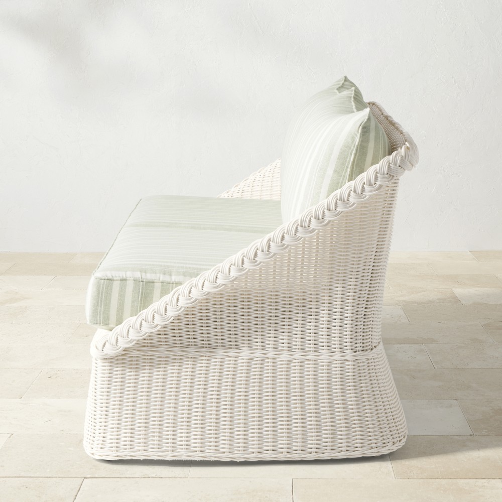 Side view of white wicker outdoor sofa showing slope and cushion
