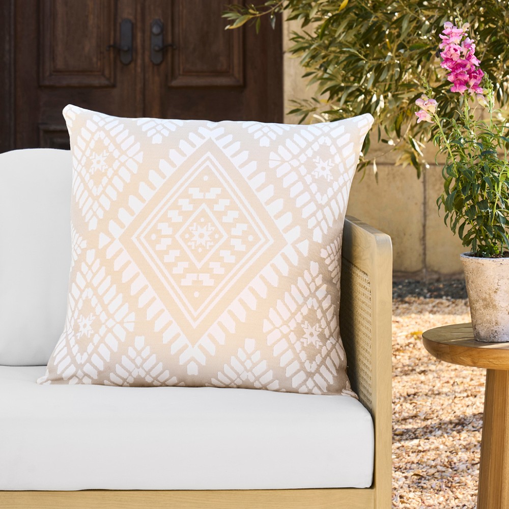 Beige/tan geometric patterned outdoor pillow on a chair