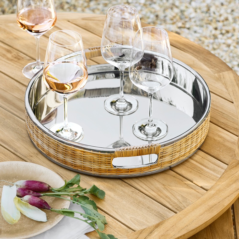 Round metal tray on wooden table with wine glasses