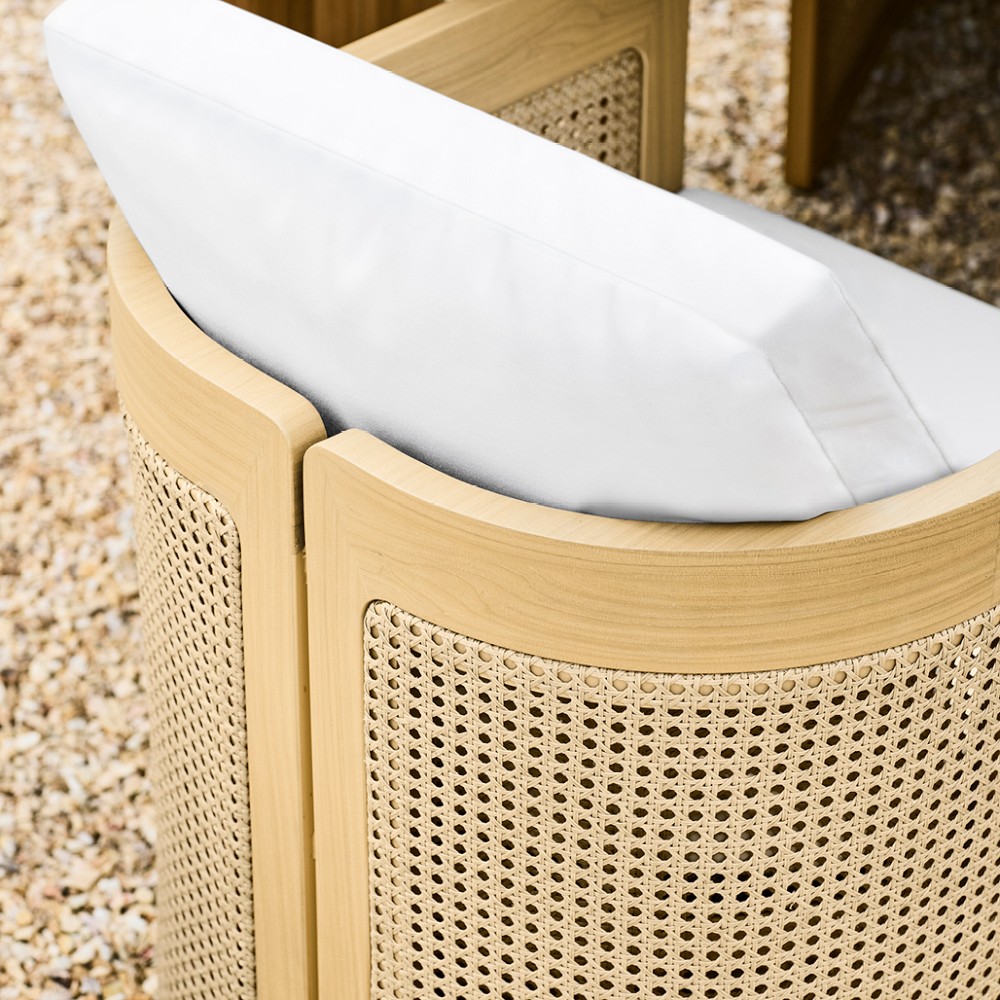 Curved wooden armrest with woven panel and white cushion