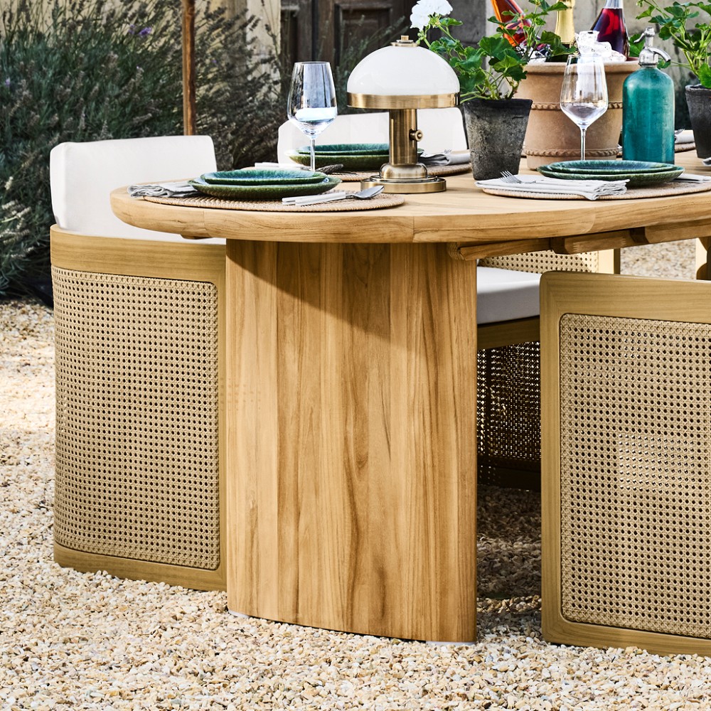 Close-up of oval wooden dining table with built-in pedestal base